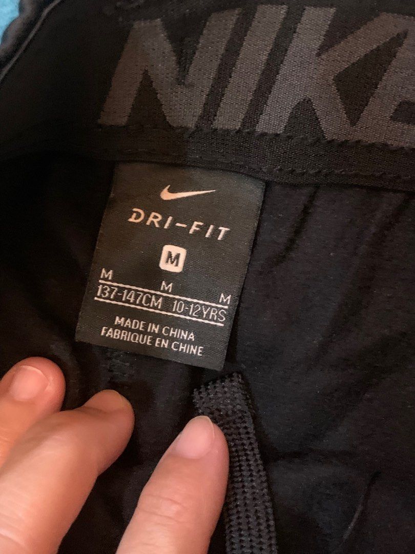 Nike Dri-FIT Tracksuit Set - Black (Category: Babies & Kids Fashion) located in Cainta. Submitted by JCJ_shoppe (Listing ID 1409639973, Image 3). Description: ORIGINAL Nike Dri-FIT tracksuit set - Color: Black - Includes: Long-sleeved top and pants - Size: M (fits 10-12 year olds) - Features Nike logos on top and pants - Accents: Grey on sleeves and collar - No flaws / damage.