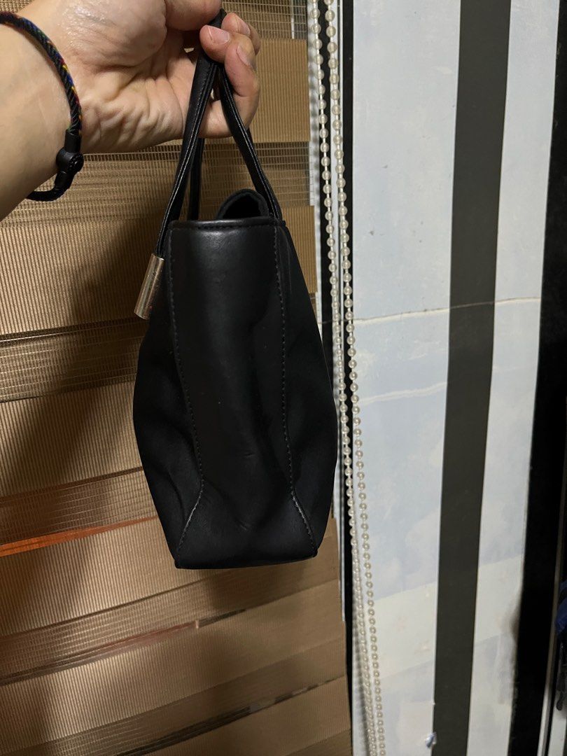 Black Handbag with Silver Accents (Category: Luxury Bags & Wallets) located in Bulacan. Submitted by sef19 (Listing ID 1409822619, Image 3). Description: - Black handbag - Silver accents on handles - Zippered interior pocket - Rectangular shape - Structured design - Black leather handles - Black interior lining.