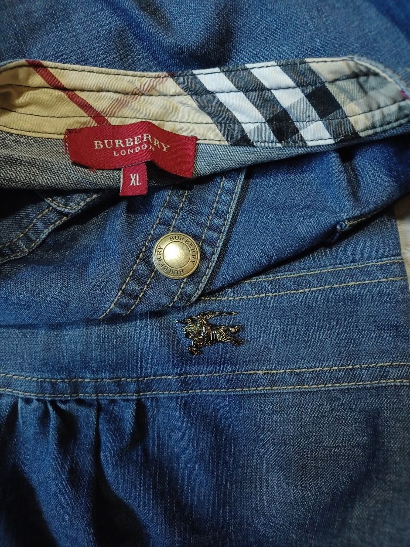 Burberry Denim Dress (Category: Dresses) located in Pasig City. Submitted by Magdythrift23 (Listing ID 1409917119, Image 2). Description: - Authentic Burberry denim dress - Size: XL - Button-down front - Short sleeves - Burberry check pattern on collar and cu - Denim material.