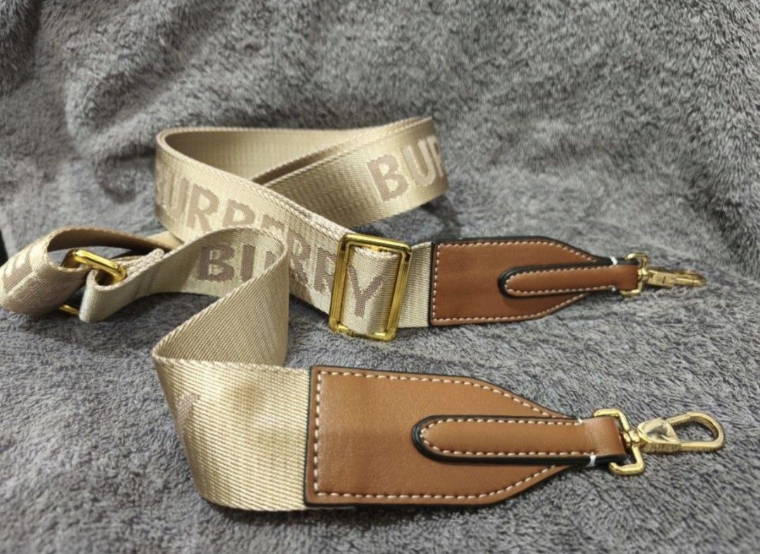 Super Sale!!! Burberry Note 2-Way Bag (Category: Luxury Bags & Wallets) located in Manila. Submitted by rjp25 (Listing ID 1409990786, Image 2). Description: - Beige strap with Burberry logo print - Brown leather ends - Gold-tone hardware - Includes two clasps for easy bag attachment - Stylish accessory.