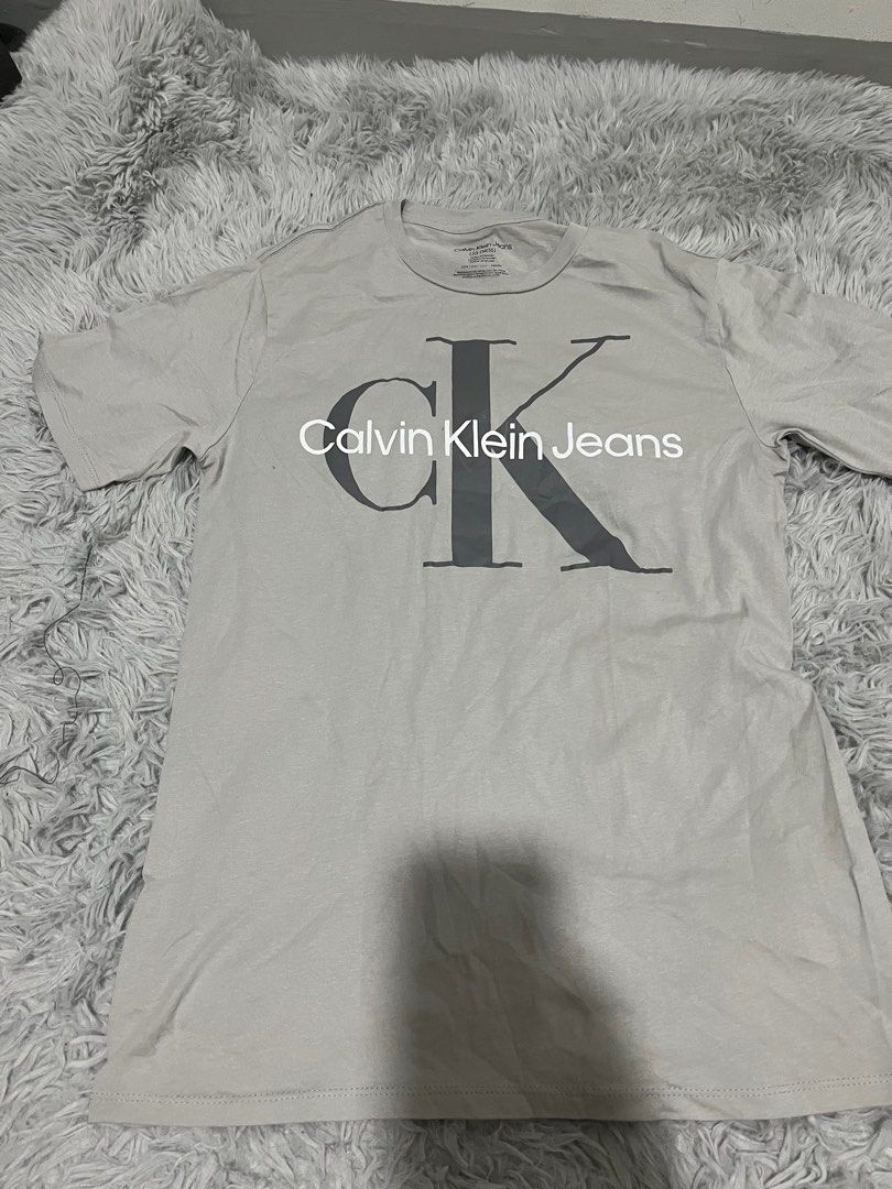 Calvin Klein Jeans T-shirt - Large (Category: Tshirts & Polo Shirts ) located in Pasig City. Submitted by ecfcloset (Listing ID 1409894287, Image 1). Description: - Calvin Klein Jeans T-shirt - Light gray color - Size: Large (14/16) - Features Calvin Klein Jeans logo - Made in Bangladesh - Material: 100% cotton.
