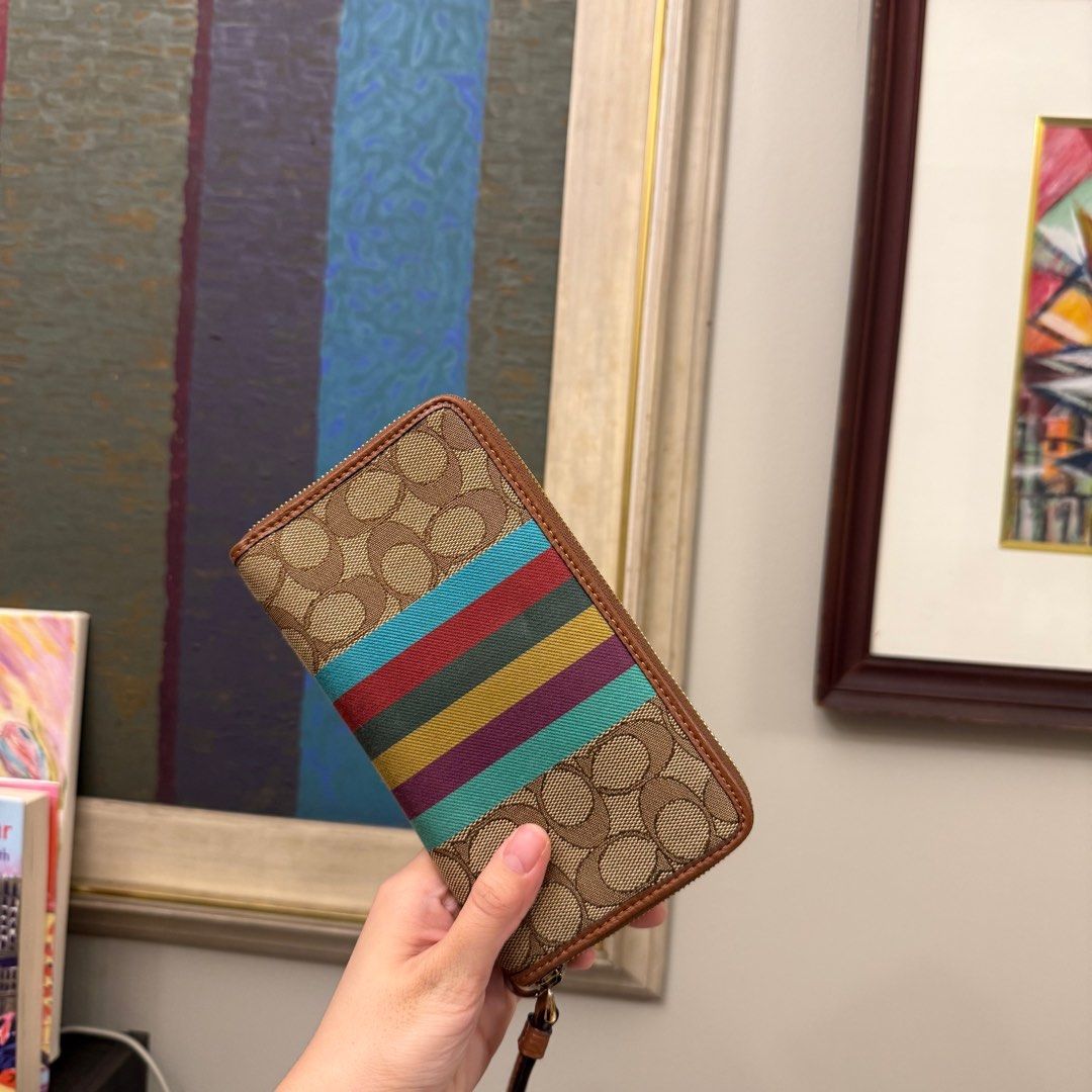 Coach Signature Stripe Wallet (Category: Wallets & Card holders) located in Quezon City. Submitted by ncpp16 (Listing ID 1409966595, Image 2). Description: - Authentic Coach wallet - Signature Coach pattern with colorful stripe - Zip-around closure - Includes wrist strap - Features Coach logo patch.
