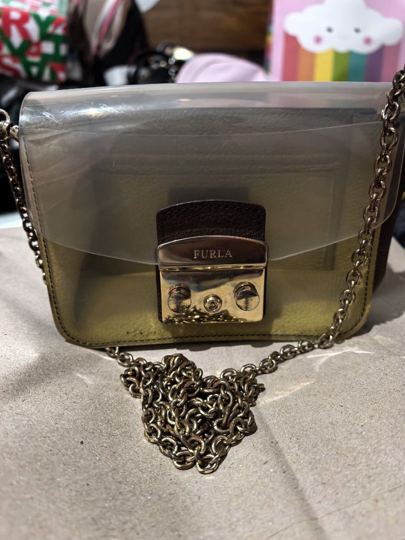Furla Mini Crossbody Bag (Category: Luxury Bags & Wallets) located in Cagayan de Oro. Submitted by tommygurl1218 (Listing ID 1409910133, Image 1). Description: - Furla mini crossbody bag - Transparent flap - Gold-tone clasp - Gold chain strap - Rectangular shape - Color scheme: Gold and olive green - Authentic Furla.