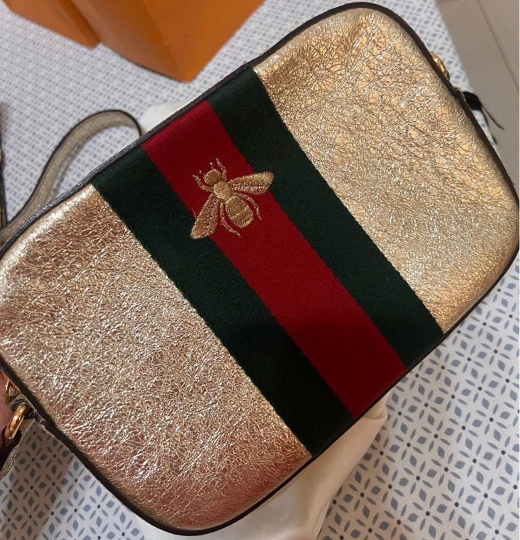 Gucci Bee Stripe Shoulder Bag (Category: Luxury Bags & Wallets) located in Paranaque City. Submitted by sharen192190 (Listing ID 1409964374, Image 1). Description: - Gold-toned shoulder bag - Features green and red stripe - Embroidered bee emblem - Includes shoulder strap - Rectangular shape - Textured exterior.