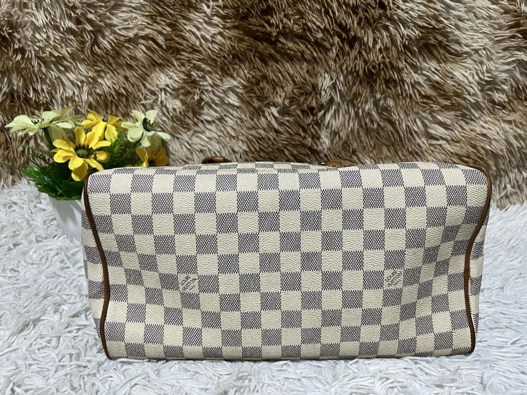 Louis Vuitton Damier Azur Speedy 25 (Category: Luxury Bags & Wallets) located in Toledo. Submitted by silverearth.bbc804 (Listing ID 1409856910, Image 3). Description: Louis Vuitton Speedy 25 handbag in Damier Azur canvas. Features brown leather trim, handles, and a top zipper closure. Includes a padlock with keys and a leather clochette. The bag has a classic checkered pattern and is a popular size for everyday use..