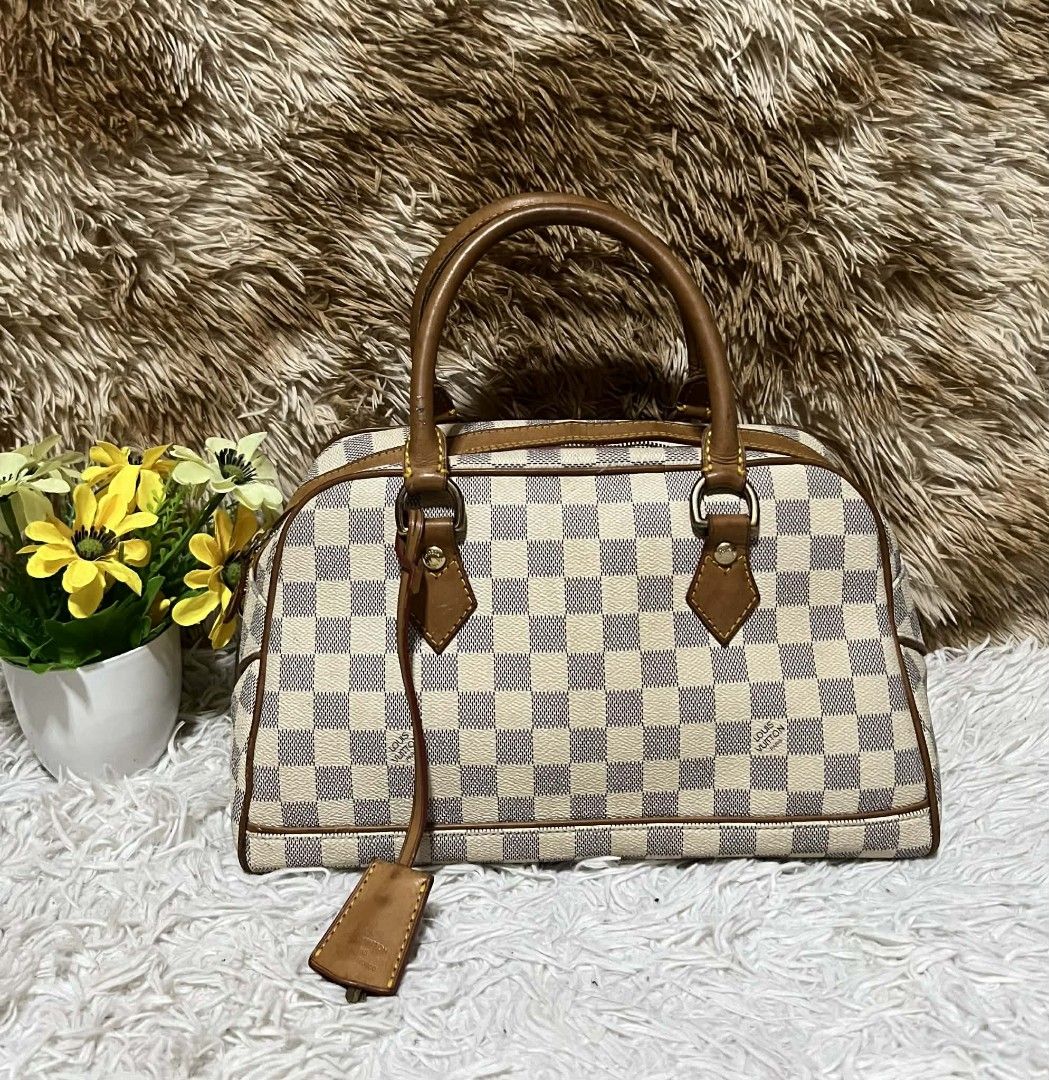 Louis Vuitton Damier Azur Speedy 25 (Category: Luxury Bags & Wallets) located in Toledo. Submitted by silverearth.bbc804 (Listing ID 1409856910, Image 1). Description: Louis Vuitton Speedy 25 handbag in Damier Azur canvas. Features brown leather trim, handles, and a top zipper closure. Includes a padlock with keys and a leather clochette. The bag has a classic checkered pattern and is a popular size for everyday use..