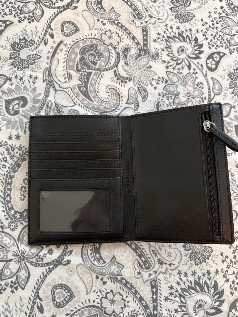 Michael Korss Passport Wallet (Category: Wallets & Card holders) located in Baliuag. Submitted by jaredcarousel (Listing ID 1409809621, Image 3). Description: - Authentic Michael Kors wallet - Black monogram pattern - Multiple card slots - Clear ID window - Zippered compartment - Compact size - Made of leather - Michael Kors logo on front 1999 (Shipped).