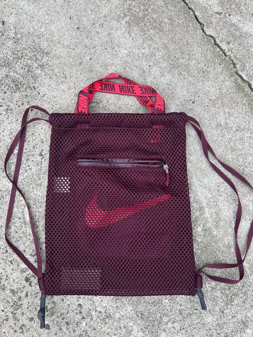 Nike Mesh Drawstring Bag (Category: Backpacks) located in Baguio. Submitted by maadeinjapaan (Listing ID 1409816239, Image 1). Description: - Nike drawstring bag - Burgundy color - Large red Nike logo - Mesh design - Zippered front pocket - Red handle with Nike logo - Drawstring straps.