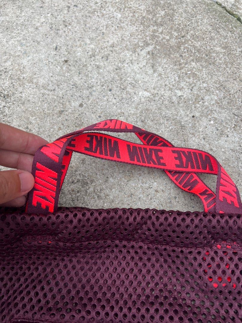 Nike Mesh Drawstring Bag (Category: Backpacks) located in Baguio. Submitted by maadeinjapaan (Listing ID 1409816239, Image 3). Description: - Nike drawstring bag - Burgundy color - Large red Nike logo - Mesh design - Zippered front pocket - Red handle with Nike logo - Drawstring straps.
