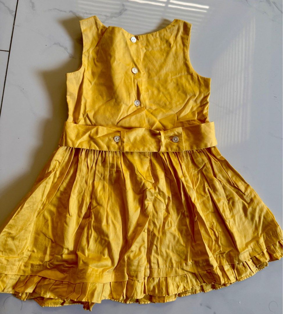 Periwinkle Yellow Dress 1Y (Category: Babies & Kids Fashion) located in Makati City. Submitted by larcie (Listing ID 1409821001, Image 3). Description: - Periwinkle yellow dress - Size: 1Y - Sleeveless design - Pleated bodice with floral accents - Bow detail at waist - Pleated skirt - Button closures at the back - Perfect for special occasions.