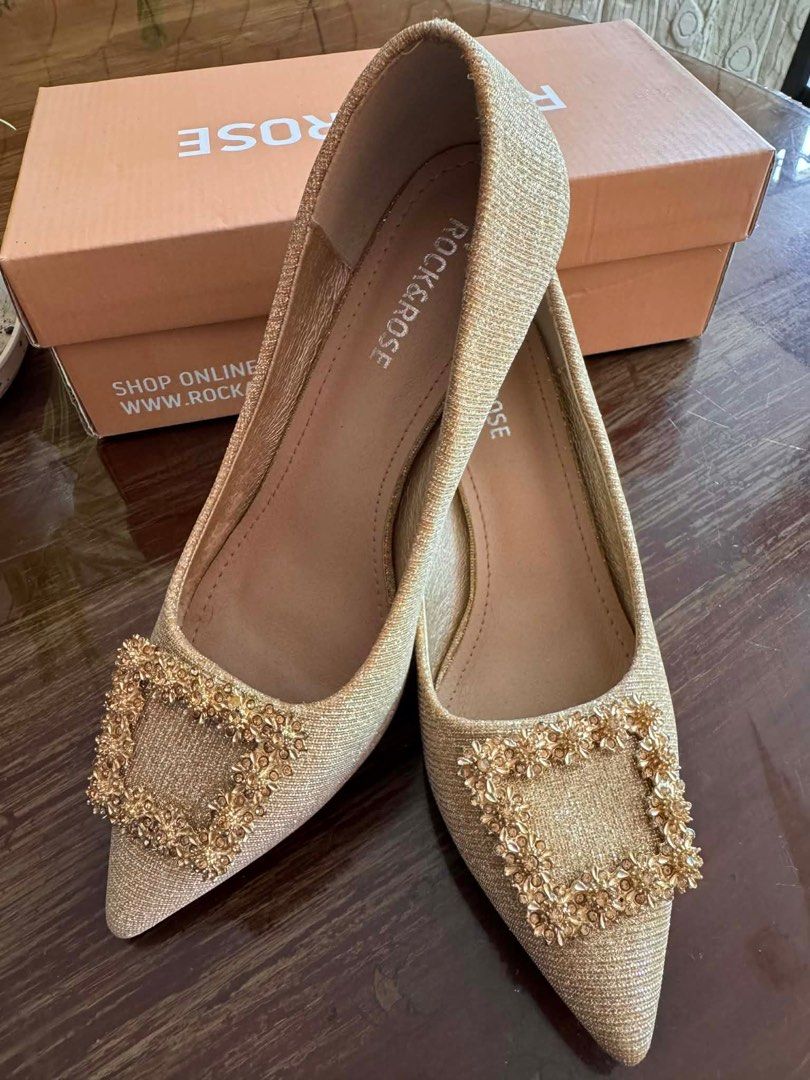 Rock & Rose Venus Heels - Size 36 (Category: Heels) located in Cavite. Submitted by hardt0get (Listing ID 1409859643, Image 1). Description: Elegant Rock & Rose Venus heels in size 36. Features a gold glittery finish with a decorative buckle. Comes with the original box. The heels have a pointed toe and a small heel. The soles are black. The box shows the original price of ₱999.00..