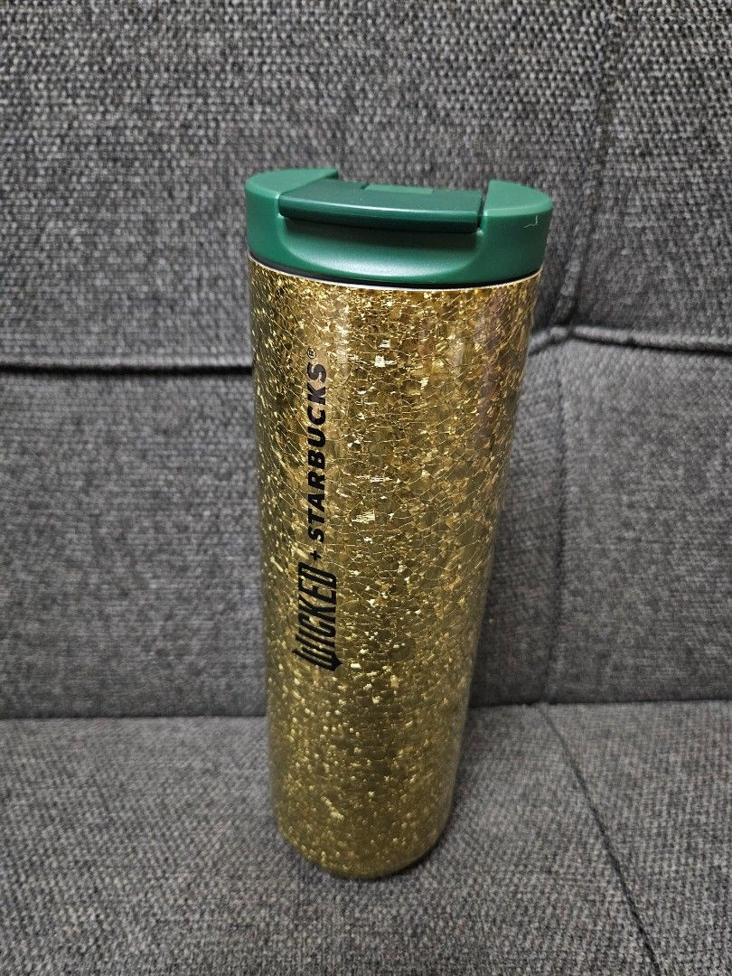 Starbucks Wicked Tumbler (Category: Water Bottles & Tumblers) located in Quezon City. Submitted by petite_kopichesg (Listing ID 1409819308, Image 2). Description: - Starbucks + Wicked tumbler with gold glitter design - Features a green lid - Includes a gold charm and chain - "Wicked + Starbucks" logo - Clean interior - Excess / Declutter - All sales are final - No return, no refund - Will not release item, if not yet paid .
