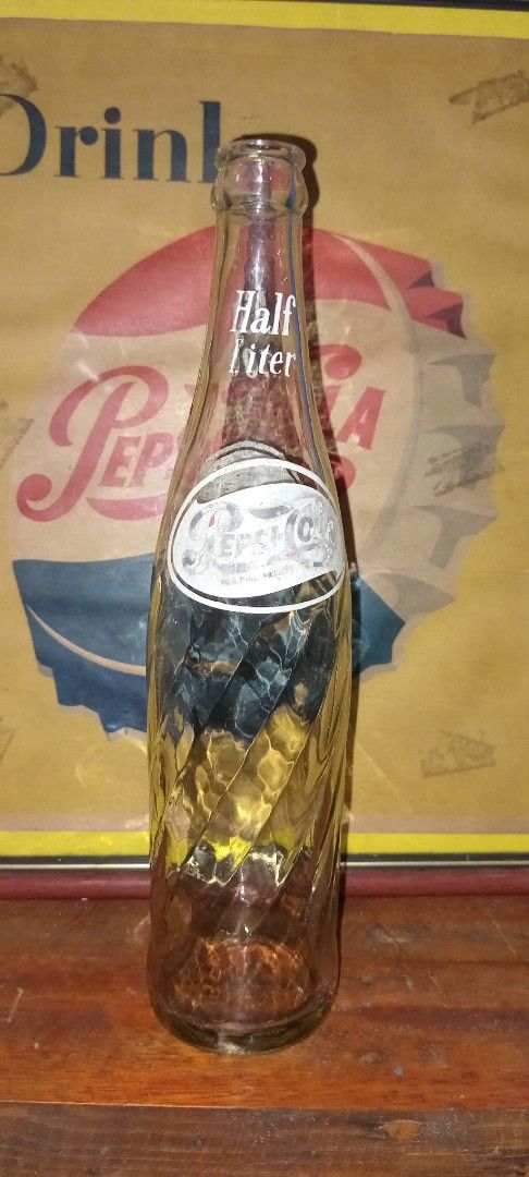 Vintage Pepsi Bottle (Category: Vintage Collectibles) located in Manila. Submitted by iamrich110502 (Listing ID 1409810890, Image 1). Description: - Vintage Pepsi bottle - Features the Pepsi logo - Unique twisted design - Half Liter / Big 500 size - Great for collectors of soda memorabilia.