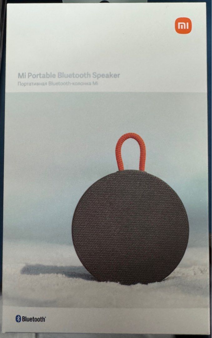 Xiaomi Mi Portable Bluetooth Speaker (Category: Soundbars, Speakers & Amplifiers) located in Quezon City. Submitted by decluttering.doc (Listing ID 1409847083, Image 1). Description: Mi Portable Bluetooth Speaker. It has a round shape with a fabric-like texture and a handle. The speaker is in its original packaging. It features Bluetooth connectivity for wireless audio streaming. The box has the Mi logo and the Bluetooth logo..