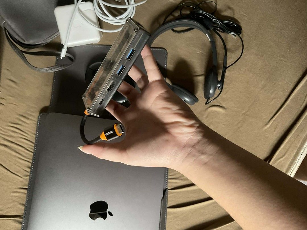 Apple MacBook Charger, Mouse, Hub, and Accessories (Category: Laptops & Notebooks) located in Pasay City. Submitted by alexocrenas75 (Listing ID 1410026318, Image 3). Description: - Apple MacBook Charger (white adapter, USB-C cable) - Black Logi Mouse - Multi-port USB Hub - Gray Laptop Sleeve - Headset.