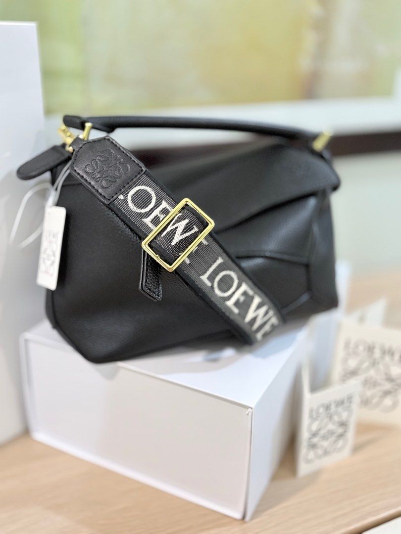 Authentic vegan leather Loewe Puzzle bag + jacquard strap with receipt (Category: Luxury Bags & Wallets) located in Manila. Submitted by pursonalshopper (Listing ID 1410178092, Image 2). Description: Loewe Small Puzzle Bag Pm me for receipt pre loved. material: calfskin leather COMPLETE INCLUSIONS: ✅Dustbag ✅Box & paperbag ✅Extra Loewe Sling strap ✅Authenticity card Dimensions: approximately 24 cm (width) x 16.5 cm (height) x 10.5 cm (depth), or 