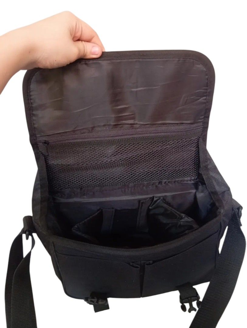 Canon camera bag (Category: Camera Bags & Carriers) located in Andop. Submitted by source8600 (Listing ID 1410101189, Image 2). Description: black Canon Digital Gadget Bag, likely the 300DG model. It is a shoulder bag designed to carry DSLR camera gear, including a camera body, lenses, and accessories. The main compartment features four padded, removable dividers to organize equipment. The interior lining is light gray nylon to help identify gear