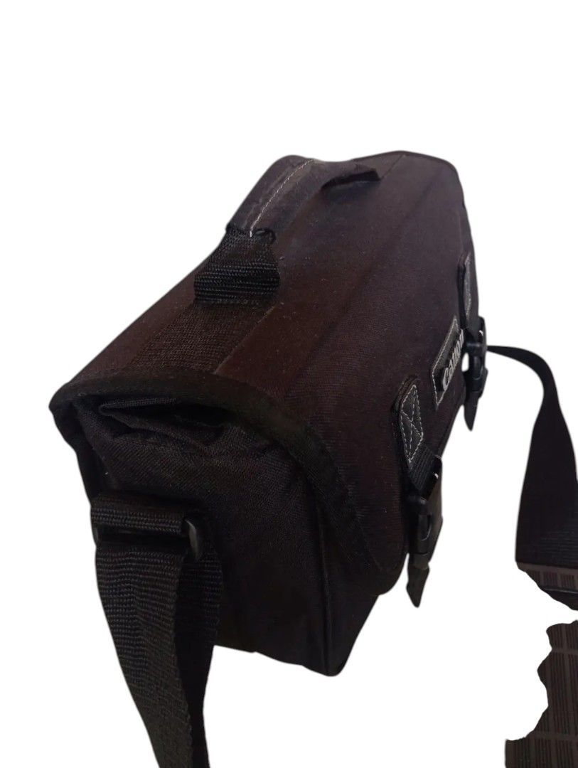 Canon camera bag (Category: Camera Bags & Carriers) located in Andop. Submitted by source8600 (Listing ID 1410101189, Image 3). Description: black Canon Digital Gadget Bag, likely the 300DG model. It is a shoulder bag designed to carry DSLR camera gear, including a camera body, lenses, and accessories. The main compartment features four padded, removable dividers to organize equipment. The interior lining is light gray nylon to help identify gear
