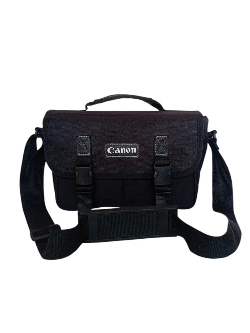 Canon camera bag (Category: Camera Bags & Carriers) located in Andop. Submitted by source8600 (Listing ID 1410101189, Image 1). Description: black Canon Digital Gadget Bag, likely the 300DG model. It is a shoulder bag designed to carry DSLR camera gear, including a camera body, lenses, and accessories. The main compartment features four padded, removable dividers to organize equipment. The interior lining is light gray nylon to help identify gear