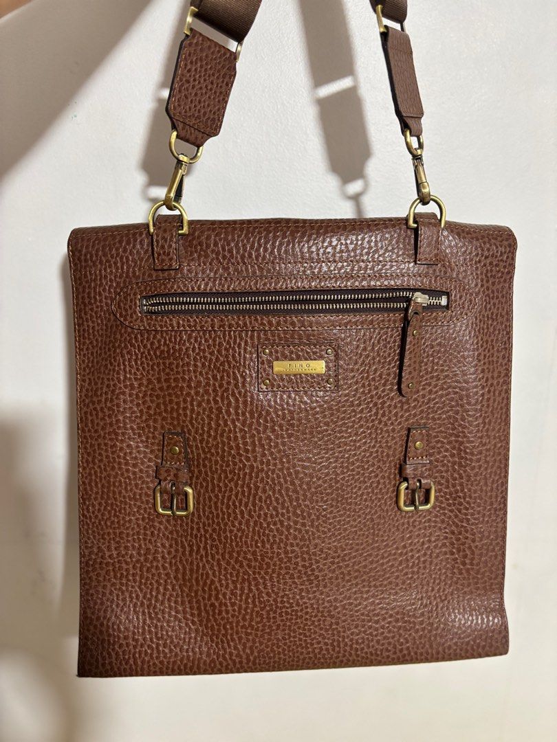 Fino Leather Tote Bag (Category: Tote Bags) located in Manila. Submitted by gshopcollectibles (Listing ID 1410106499, Image 2). Description: - Lino brown leather tote bag - Top handle and detachable shoulder strap - Front flap closure with buckle details - Interior: zippered pocket and multiple compartments - Textured leather exterior - Gold-tone hardware.