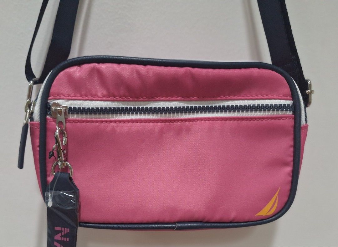 Nautica Pink Crossbody Bag (Category: Cross-body Bags) located in Quezon City. Submitted by thriftforkeeps (Listing ID 1410091349, Image 2). Description: - Nautica crossbody bag - Vibrant pink exterior - Navy blue strap - Zippered main compartment - Small back pocket - Nautica branded strap detail - Nautica logo on front - Light blue interior - Compact size - Ideal for everyday use.