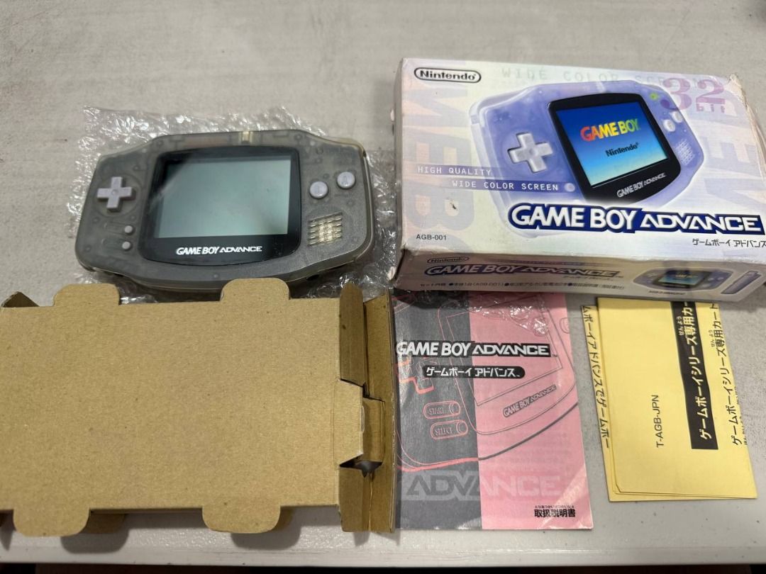 Nintendo Game Boy Advance CIB with box (Category: Nintendo) located in Manila. Submitted by pael92 (Listing ID 1410175524, Image 1). Description: - Nintendo Game Boy Advance console for sale. - Translucent gray color. - Includes original box and manuals. - Box art features a purple Game Boy Advance. - Standard button layout. - Console is in good working condition..