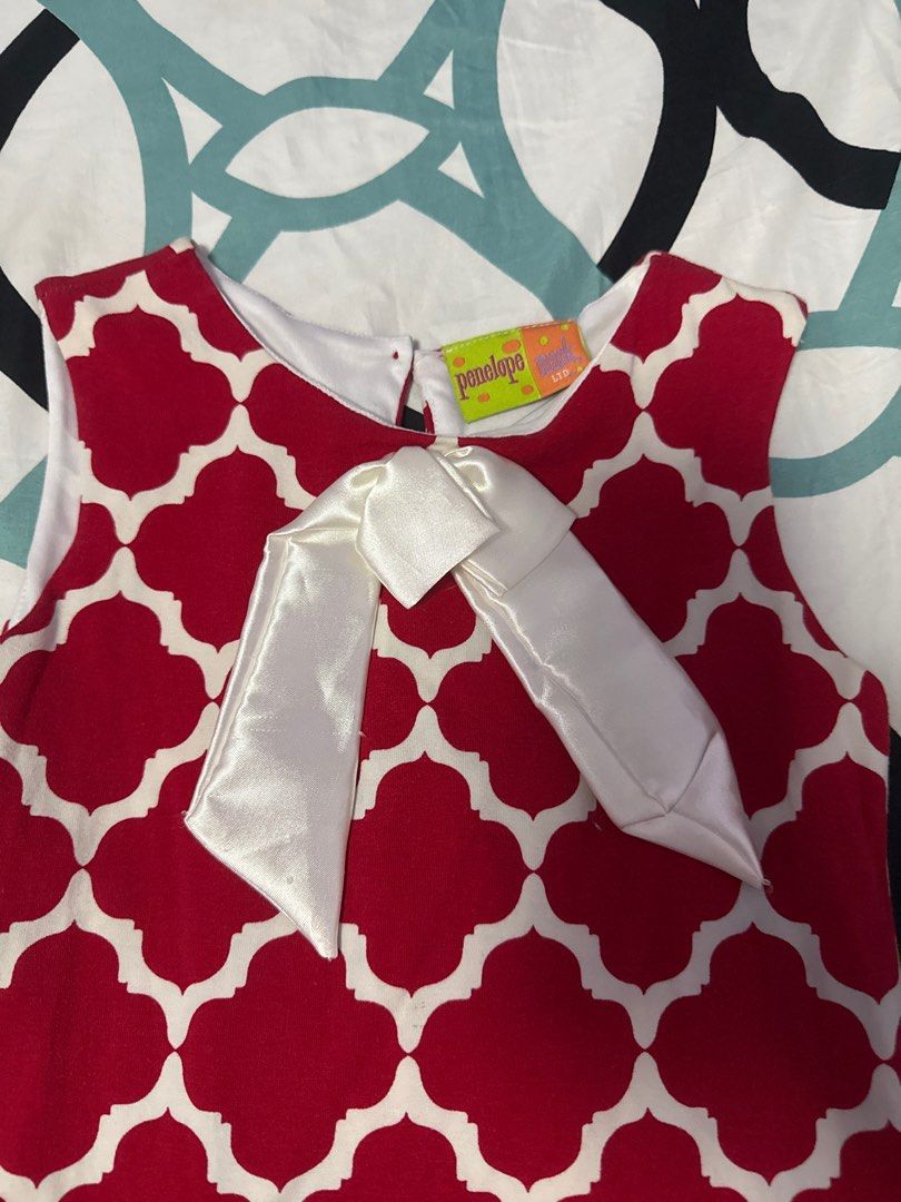 Penelope Red and White Dress (Category: Babies & Kids Fashion) located in Bacoor. Submitted by rizza_455 (Listing ID 1410091751, Image 2). Description: - Penelope dress in red and white. - Features a quatrefoil pattern. - Includes a white bow detail. - Sleeveless design. - Ideal for warm weather and young girls. 2 yrs old.