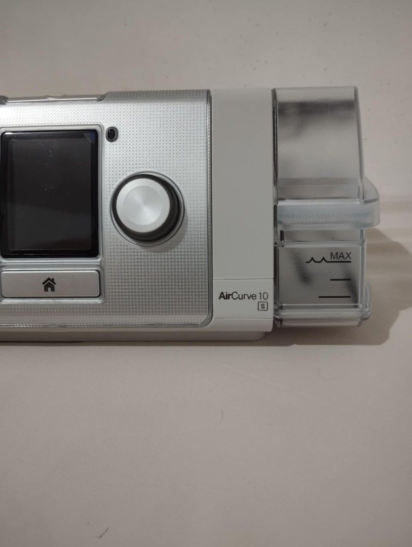 ResMed AirCurve 10 S BiPAP Machine (Category: Medical Supplies & Tools) located in Manila. Submitted by be_sure (Listing ID 1410084241, Image 1). Description: ResMed AirCurve 10 S BiPAP machine. Features a built-in humidifier and SD card slot. The screen displays sleep report information, including usage hours and total used hours . Includes a power button and home button. The water chamber has a max fill line. The device is silver and white..
