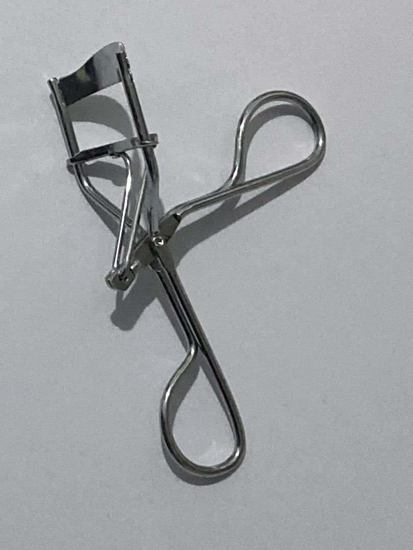 Shu Uemura Eyelash Curler (Category: Makeup) located in Del Monte. Submitted by pageturner_digital (Listing ID 1410010552, Image 3). Description: - Authentic Shu Uemura eyelash curler - Silver-colored metal construction - Ergonomic design for comfortable grip - Curved shape to fit the eye - Features the Shu Uemura logo - No foam but I can provide foam if you want..