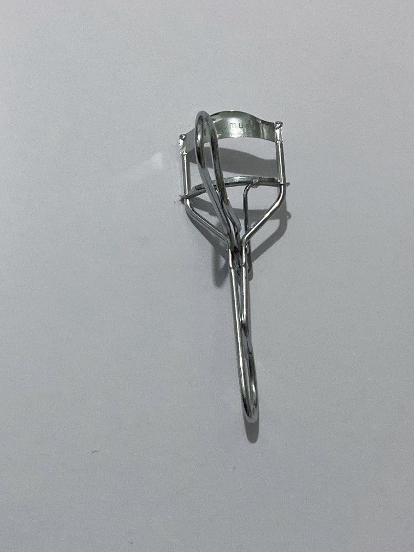 Shu Uemura Eyelash Curler (Category: Makeup) located in Del Monte. Submitted by pageturner_digital (Listing ID 1410010552, Image 1). Description: - Authentic Shu Uemura eyelash curler - Silver-colored metal construction - Ergonomic design for comfortable grip - Curved shape to fit the eye - Features the Shu Uemura logo - No foam but I can provide foam if you want..