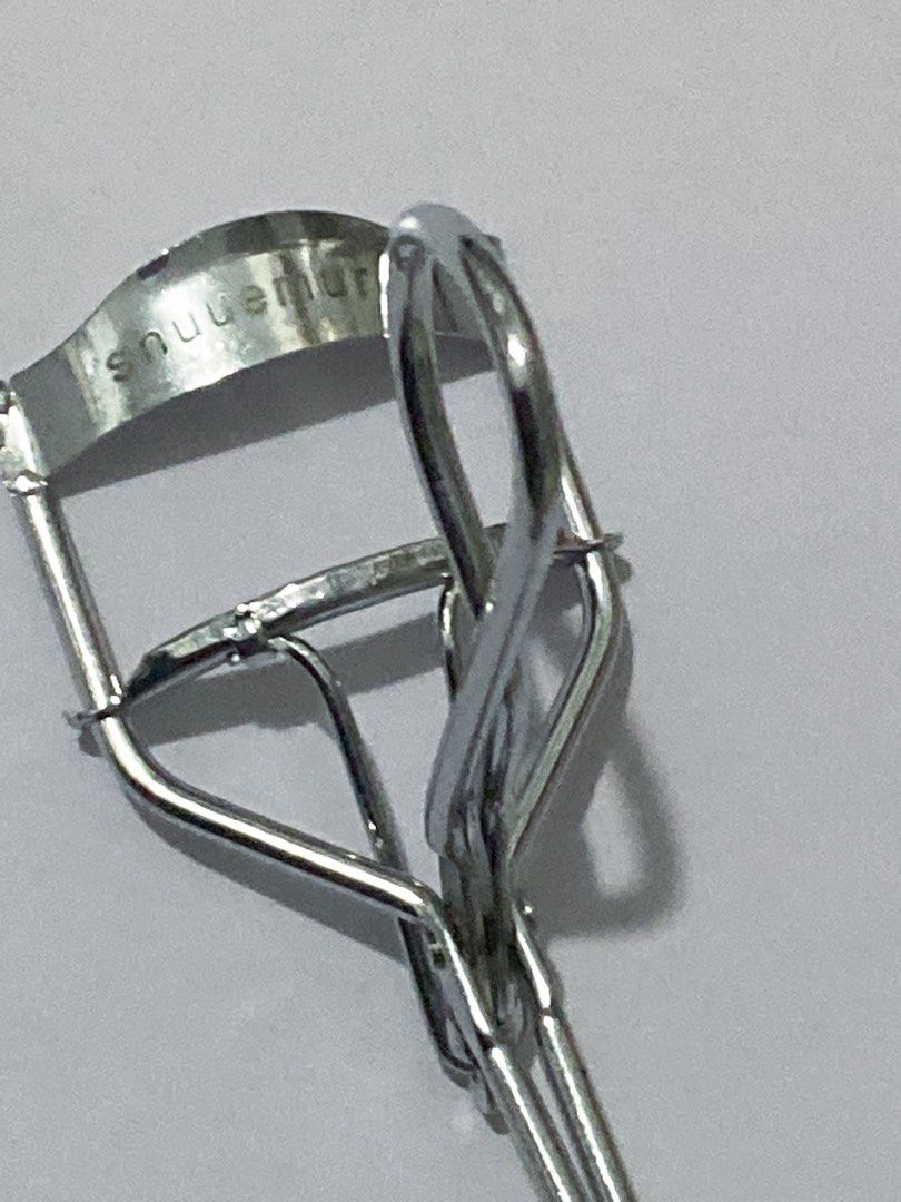 Shu Uemura Eyelash Curler (Category: Makeup) located in Del Monte. Submitted by pageturner_digital (Listing ID 1410010552, Image 2). Description: - Authentic Shu Uemura eyelash curler - Silver-colored metal construction - Ergonomic design for comfortable grip - Curved shape to fit the eye - Features the Shu Uemura logo - No foam but I can provide foam if you want..