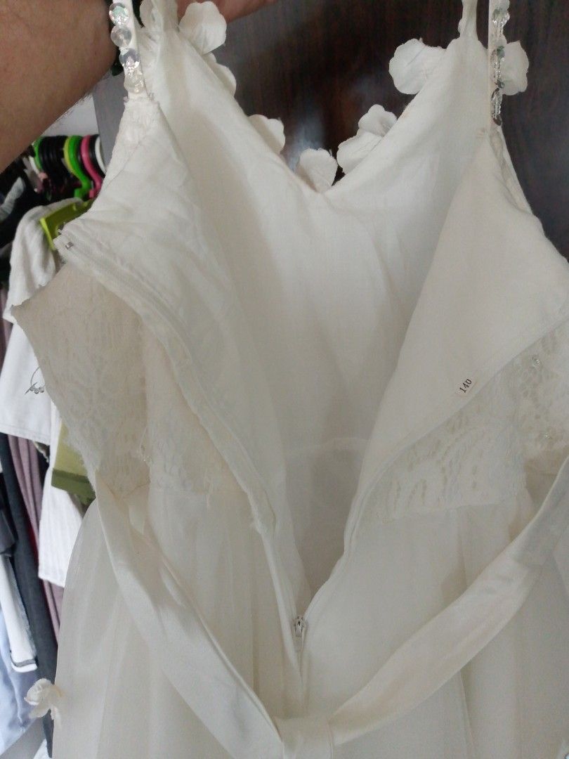 Elegant christmas dress (Category: Babies & Kids Fashion) located in Mandaluyong City. Submitted by ronald_1230 (Listing ID 1410211535, Image 3). Description: - White dress with floral details - Layered skirt design - Includes a train - Zipper closure at the back - Perfect for special occasions - Delicate floral accents on straps and bodice.