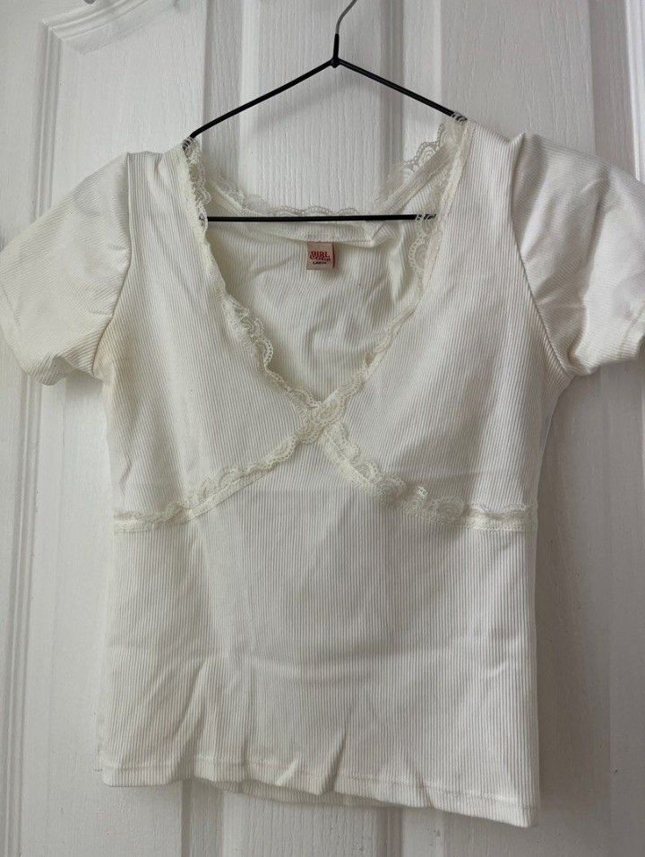 GirlCode White Coquette Ribbed Top with Lace Trim (Category: Sleeveless) located in Manila. Submitted by loveeroded (Listing ID 1410271689, Image 1). Description: - White ribbed top - V-neckline with delicate lace trim - Horizontal band detail - Short sleeves - Soft, comfortable fabric - Versatile style.