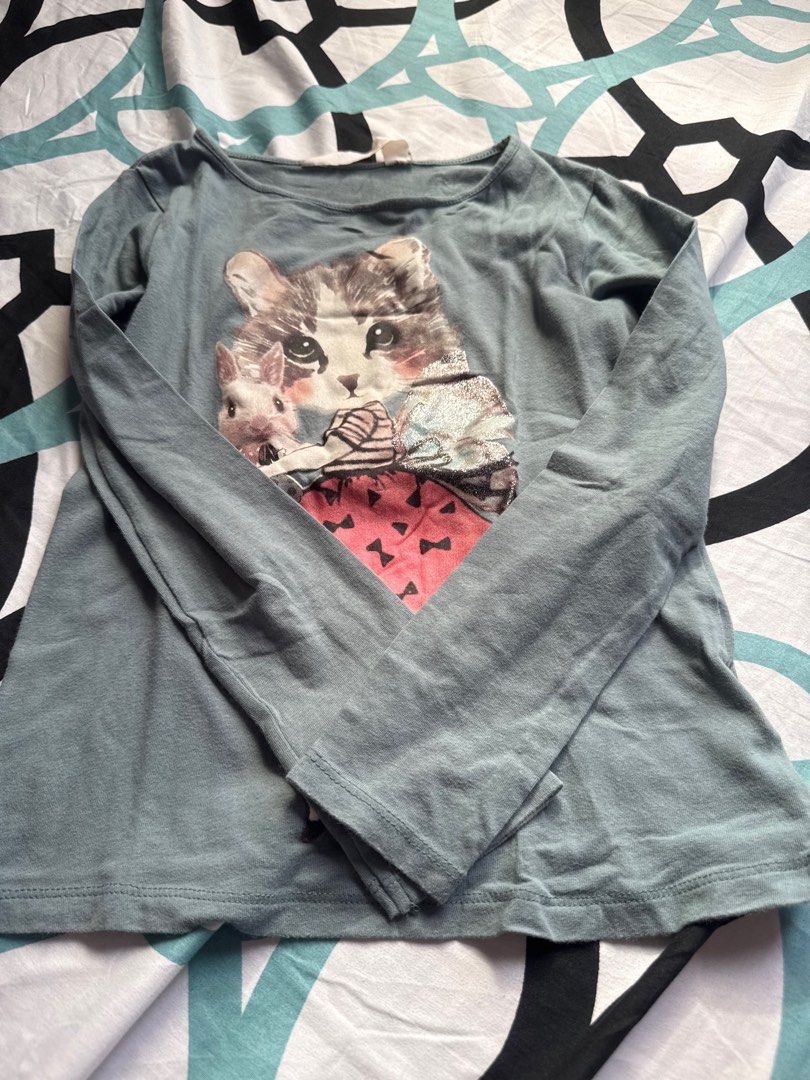 H&M Cat Print Long Sleeve Shirt (Category: Babies & Kids Fashion) located in Bacoor. Submitted by rizza_455 (Listing ID 1410190457, Image 1). Description: - Long-sleeved shirt with adorable cat print - Size: 6-8 years old - Color: Muted teal - Features a round neckline - Made from soft, comfortable fabric - Perfect for everyday wear fit to 4-5 yrs old.