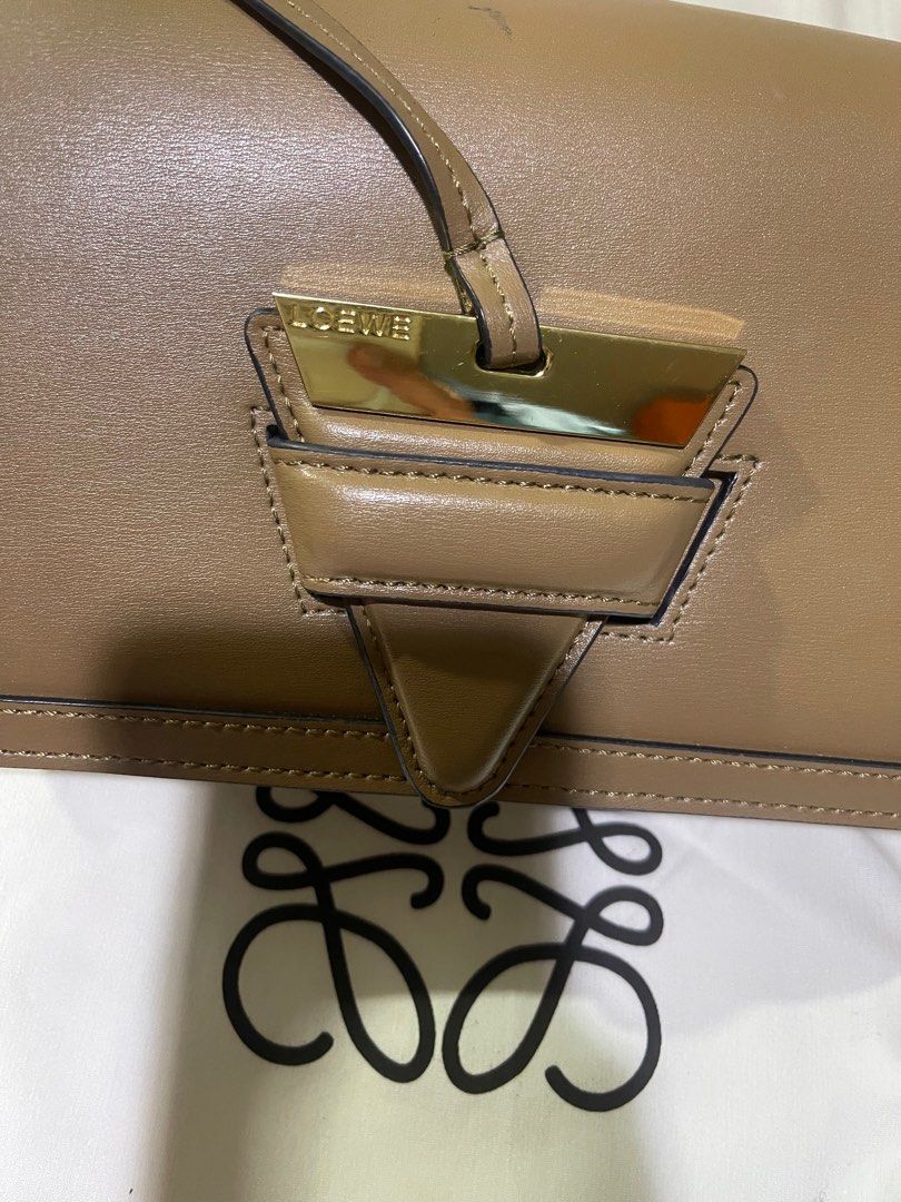 Loewe Puzzle Bag (Category: Luxury Bags & Wallets) located in Rizal. Submitted by catchyfinds (Listing ID 1410247558, Image 3). Description: - Loewe Bag - Taupe color - Top handle and detachable shoulder strap - Includes 2 straps - Flap closure with gold-tone metal detail - Includes dust bag and card - Multiple interior compartments.