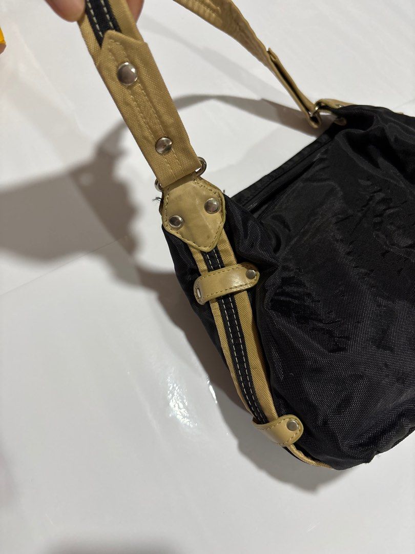 Moschino Black Shoulder Bag (Category: Luxury Bags & Wallets) located in Taguig. Submitted by passionfashion (Listing ID 1410283750, Image 3). Description: - Black shoulder bag - Beige strap - Zipper closure - Interior pocket - Moschino logo on zipper and inside - Metal stud strap attachments - Nylon or similar material.