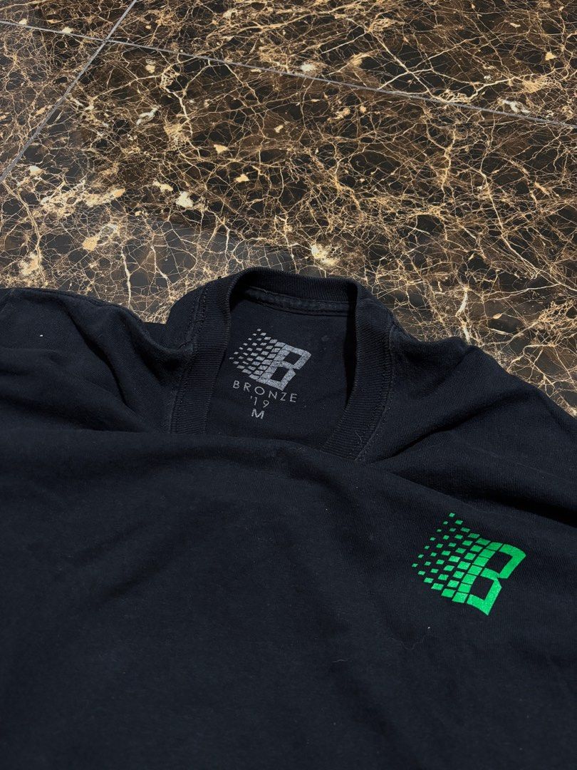 Bronze Long Sleeve Shirt (Category: Tshirts & Polo Shirts ) located in Pasig City. Submitted by functionalrags (Listing ID 1410514574, Image 2). Description: - Black long sleeve shirt - Features a green and white Bronze logo on the back and a smaller logo on the front - Crew neck design - Size: Medium - Bronze logo printed on the inside collar.