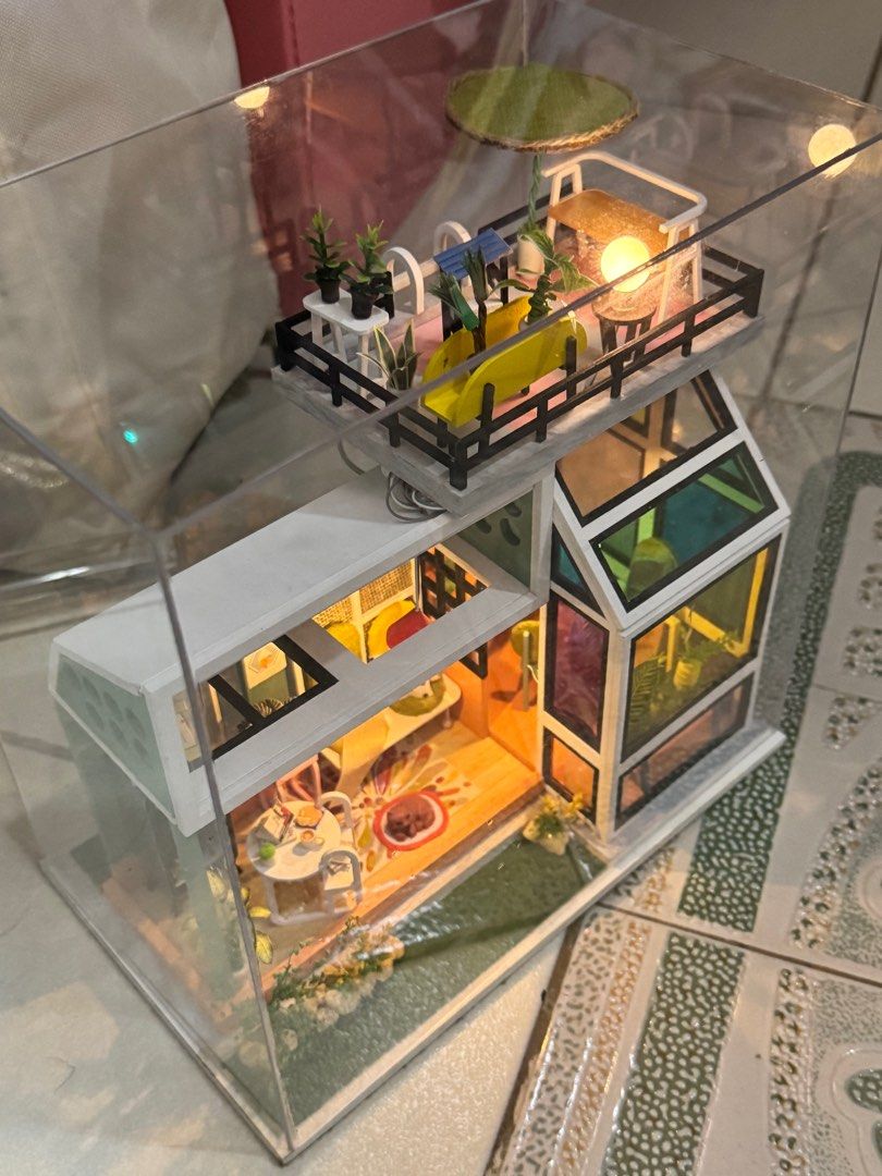 DIY Miniature Dollhouse with LED Lights (Category: Kids Toys) located in Manila. Submitted by judeo. (Listing ID 1410486293, Image 2). Description: Already build miniature!!❤️ - Modern miniature dollhouse - Features multiple rooms and a rooftop patio - Includes detailed furniture and plants - Comes with LED lighting - Enclosed in a clear display case - Perfect for collectors and decoration.
