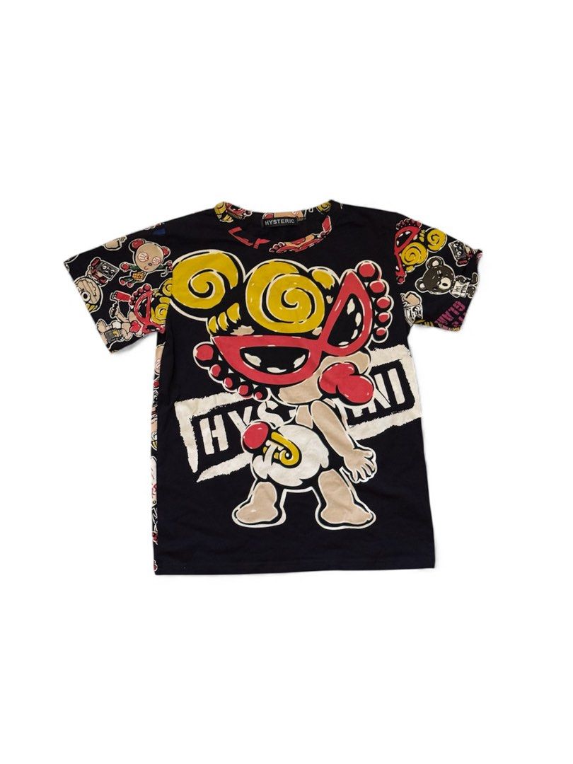 Hysteric Glamour Graphic Tee (Category: Tshirts & Polo Shirts ) located in Paranaque City. Submitted by passion_pluto (Listing ID 1410419726, Image 1). Description: - Black Hysteric Glamour graphic tee - Features a unique cartoon character design - Design includes a character with yellow hair and a red mask - Short sleeves and a classic crew neck - Sleeves adorned with cartoon character pattern - Brand name prominently displayed on the collar.
