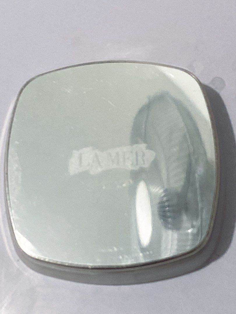 La Mer The Powder (Category: Makeup) located in Del Monte. Submitted by pageturner_digital (Listing ID 1410484457, Image 2). Description: - La Mer The Powder compact. - Silver top with La Mer logo. - Light beige powder color. - Gold-colored rim. - Square-shaped with rounded corners. - Brand new in original packaging. .