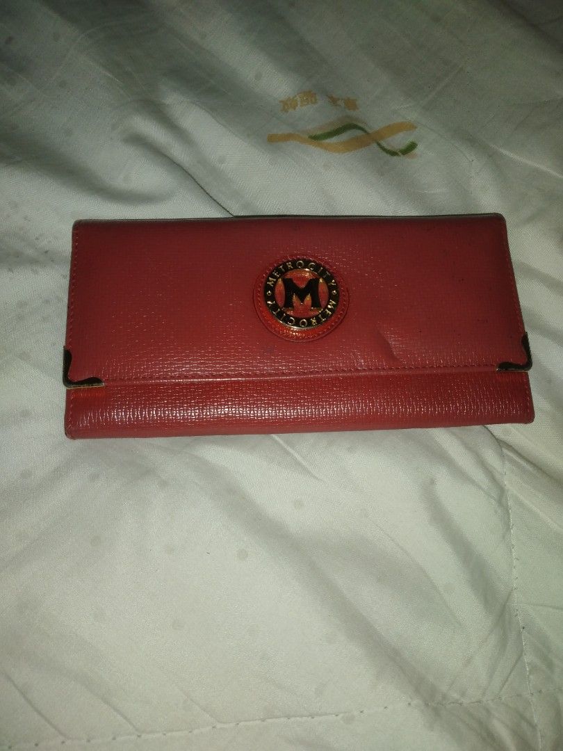 Metrocity Red Wallet (Category: Wallets & Card holders) located in Makati City. Submitted by closet.declutterph (Listing ID 1410389607, Image 2). Description: - Red wallet with gold Metrocity logo - Multiple card slots - Zippered compartment for coins/valuables - Secure snap closure - Stylish gold-colored corner accents - Textured material -Authentic metrocity.