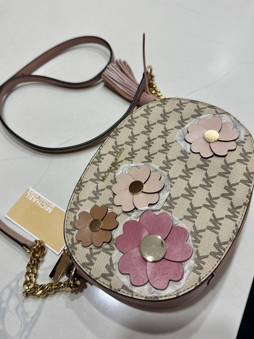 Michael Kors Flora Applique Ginny Medium Messenger bag (Category: Luxury Bags & Wallets) located in Dasmarinas. Submitted by bzbeezcar0u5el1 (Listing ID 1410399901, Image 1). Description: The Michael Kors “Flora Applique Ginny Medium Messenger” bag - never been used (due to personal preference) - has card slots inside - fits an iphone pro max - minor deformities on the bag and leather Bag Size (approximate): • Width: ~8 ½ inches (about 21.5 cm) •