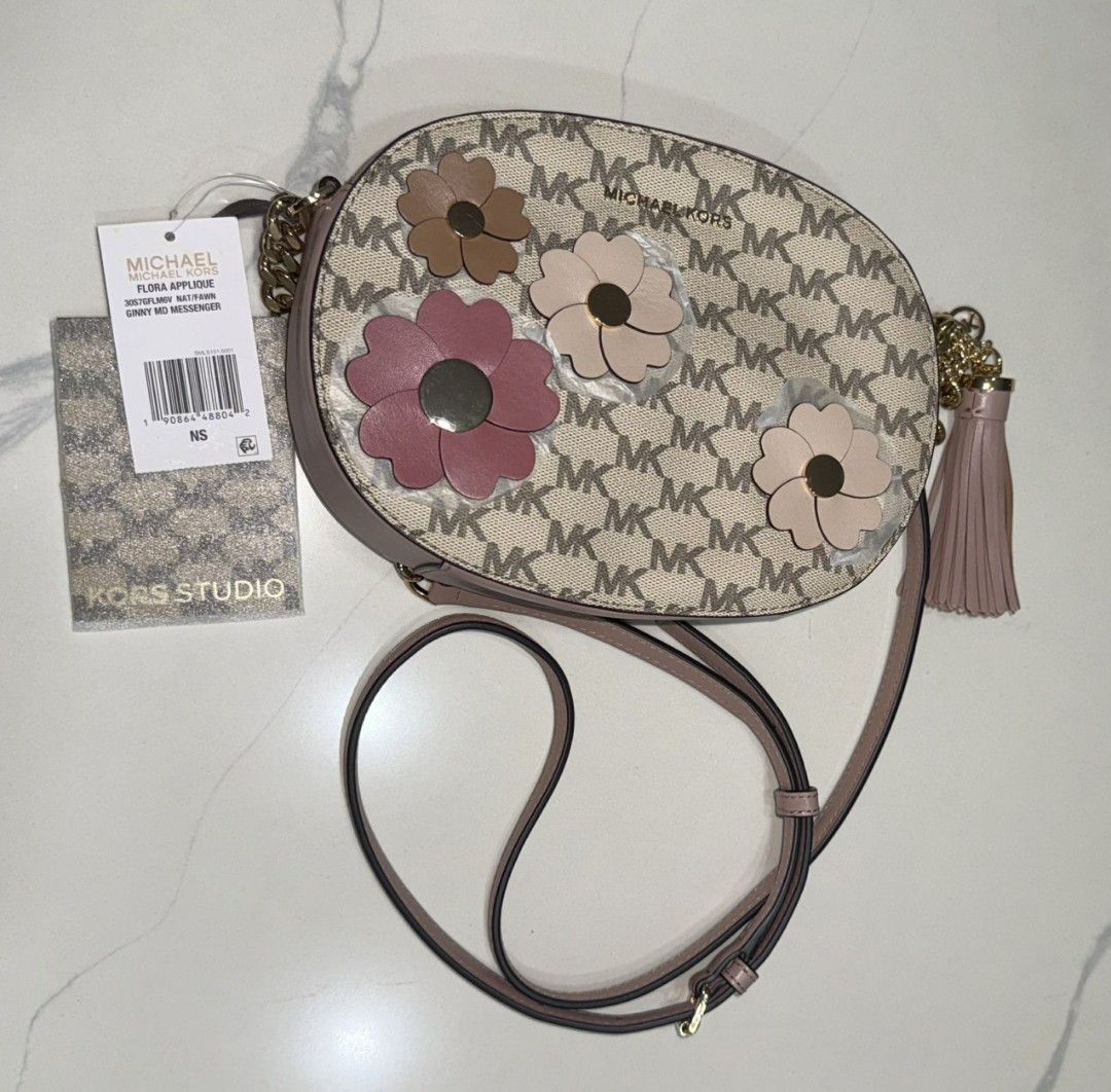 Michael Kors Flora Applique Ginny Medium Messenger bag (Category: Luxury Bags & Wallets) located in Dasmarinas. Submitted by bzbeezcar0u5el1 (Listing ID 1410399901, Image 3). Description: The Michael Kors “Flora Applique Ginny Medium Messenger” bag - never been used (due to personal preference) - has card slots inside - fits an iphone pro max - minor deformities on the bag and leather Bag Size (approximate): • Width: ~8 ½ inches (about 21.5 cm) •