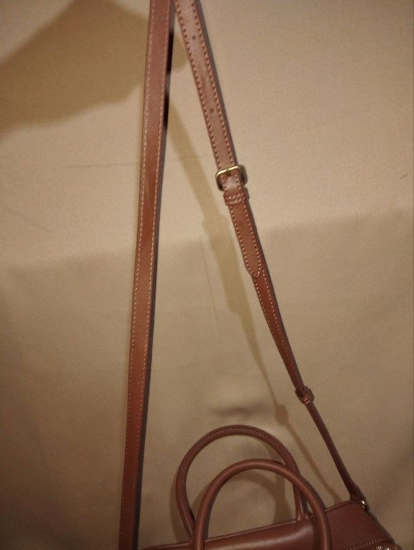Miu Miu Brown Leather Handbag (Category: Luxury Bags & Wallets) located in Pasig City. Submitted by loveforlux_2025 (Listing ID 1410512779, Image 3). Description: - Miu Miu handbag - Brown leather - Top handle and detachable shoulder strap - Embossed Miu Miu logo - Gold-toned hardware - Interior: brown fabric lining with zippered pocket - Signs of wear on interior lining and exterior - Classic and stylish design.