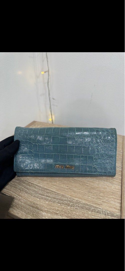 Miu Miu Crocodile Embossed Wallet (Category: Luxury Bags & Wallets) located in Makati City. Submitted by ajoloso_69 (Listing ID 1410535382, Image 1). Description: - Miu Miu wallet - Crocodile-embossed design - Light blue color - Flap closure - Gold-tone logo - Made of leather.