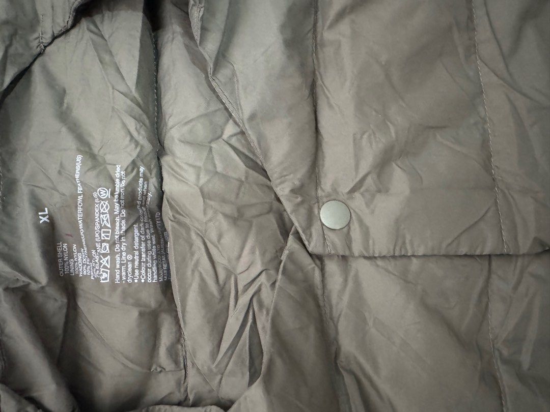 Muji Light weight down Vest (Category: Vests) located in Trece Martires City. Submitted by lakingking (Listing ID 1410401198, Image 2). Description: - Olive green vest - Size: XL - Outer shell: Nylon - Lining: Nylon/Spandex - Closure: Button - Lightweight and versatile for layering - Suitable for various weather conditions.