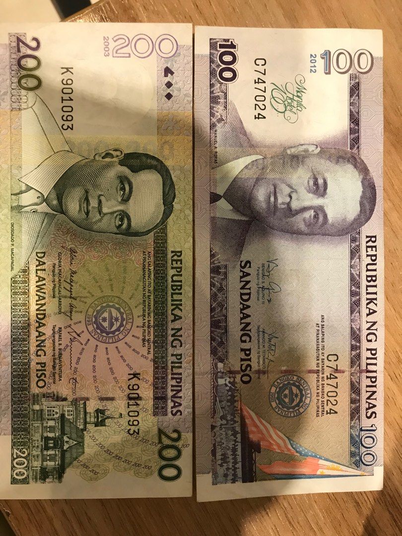 Philippine Peso 100 and 200 Banknotes (Category: Currency) located in Las Pinas. Submitted by fiercewolf_1da302 (Listing ID 1410373369, Image 1). Description: Two Philippine peso banknotes are available. One is a 200 piso bill from 2003 with serial number K901093. The other is a 100 piso bill from 2012 with serial number C747024..