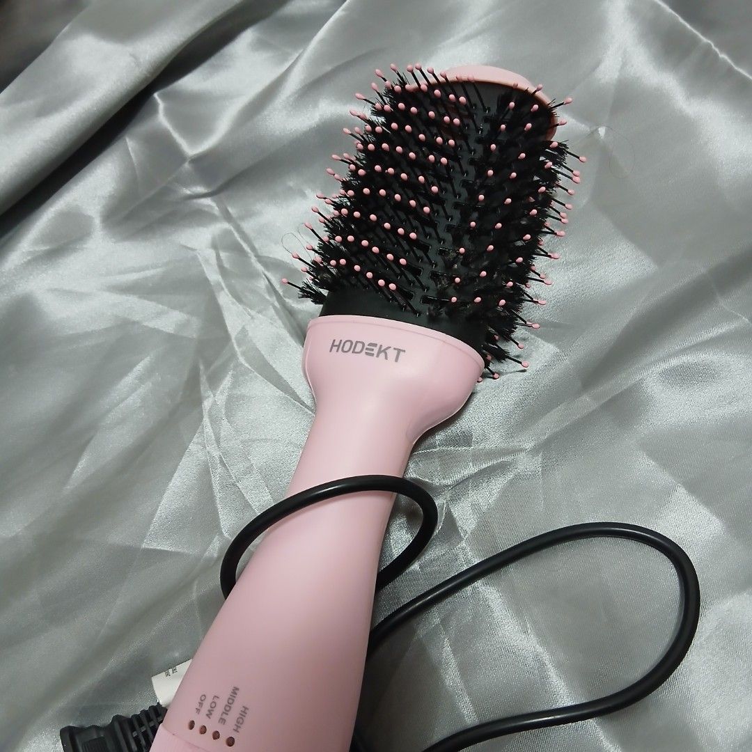 Pink Hair Dryer Brush (Category: Hair) located in Quezon City. Submitted by marceline_am (Listing ID 1410479414, Image 2). Description: - HODEKT hair dryer brush - Pink body - Round brush head - Heat settings: High, Middle, Low, Off - Black bristles with pink tips - Includes power cord.