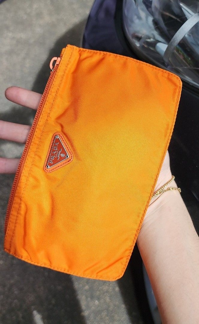 Prada Orange Tessuto Nylon Original Wallet Case Pouch Authentic (Category: Luxury Bags & Wallets) located in San Juan City. Submitted by akioza (Listing ID 1410387035, Image 1). Description: - Prada orange nylon wallet - Features a zip closure - Iconic triangular Prada logo - Compact size - Visible classic stitching - Orange zipper Classic Prada multi purpose pouch ( personal note only - g room; mid black shelf, inside LV long rectangle box. in w