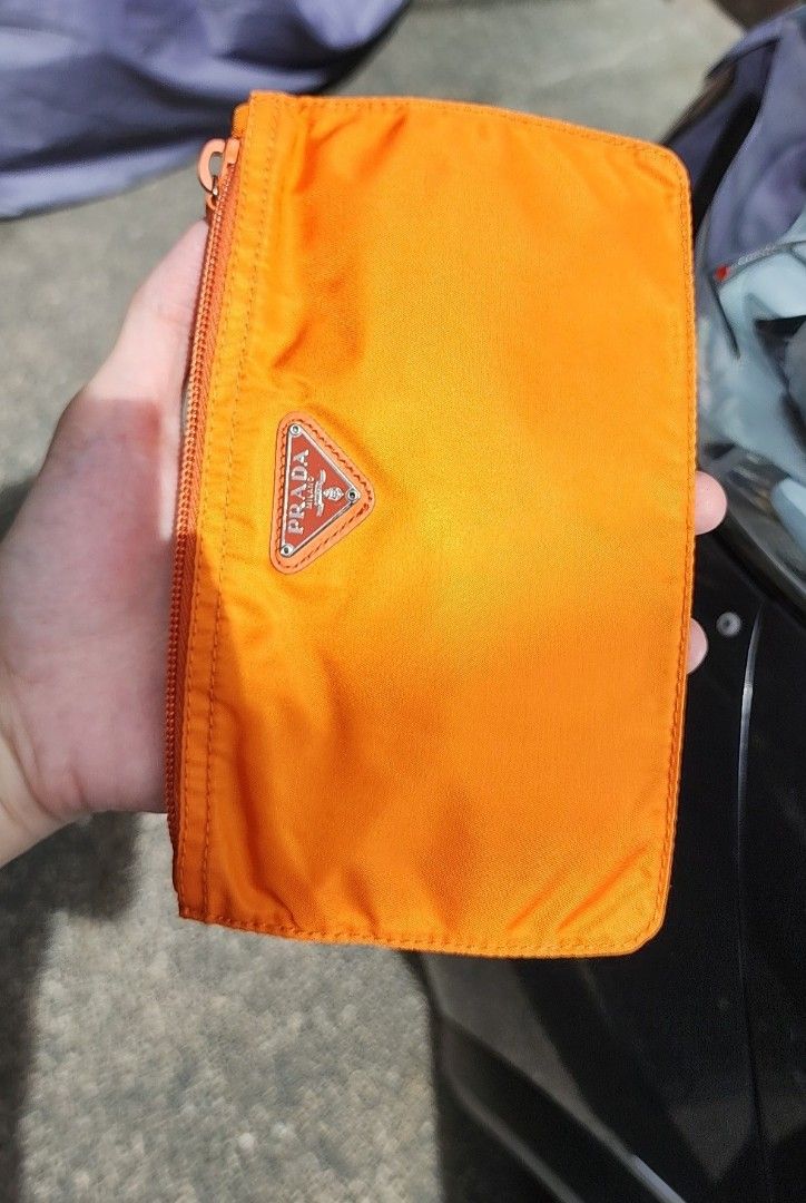 Prada Orange Tessuto Nylon Original Wallet Case Pouch Authentic (Category: Luxury Bags & Wallets) located in San Juan City. Submitted by akioza (Listing ID 1410387035, Image 3). Description: - Prada orange nylon wallet - Features a zip closure - Iconic triangular Prada logo - Compact size - Visible classic stitching - Orange zipper Classic Prada multi purpose pouch ( personal note only - g room; mid black shelf, inside LV long rectangle box. in w